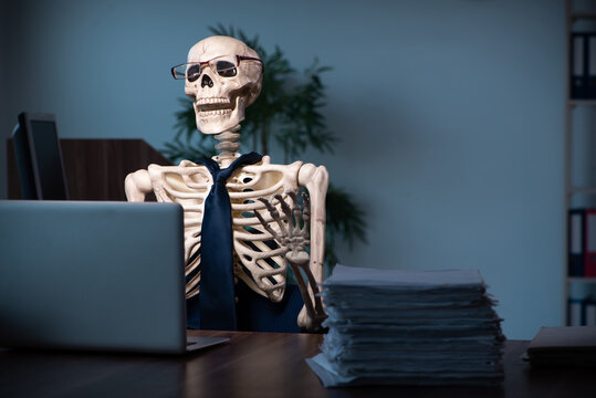 Skeleton working in front of a laptop